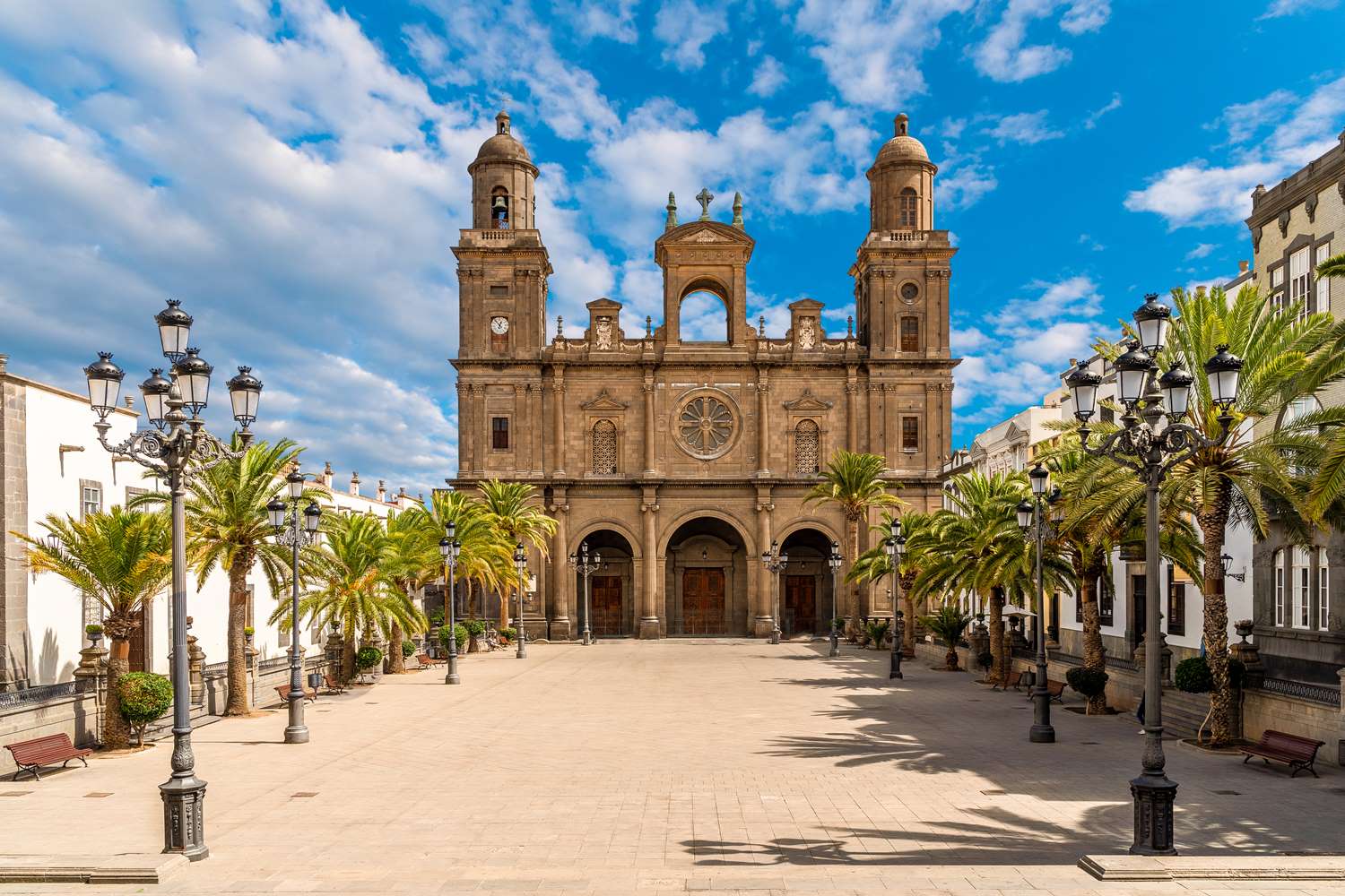 Katedralen Santa Ana i gamlebyen Vegueta i Las Palmas på Gran Canaria. Vakre palmetrær på utsiden og blå himmel.